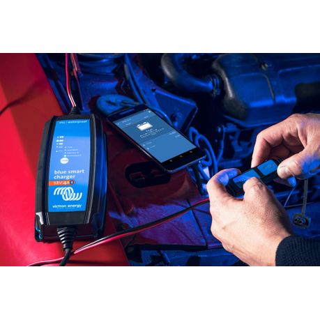 Victron Blue Smart IP65 Charger 12V 4A connected to a car battery using clamp connectors | Victron 12V 4A Blue Smart charger in action on a car battery with Bluetooth monitoring via VictronConnect app | Compact Victron IP65 charger connected to an automotive battery for maintenance and charging.